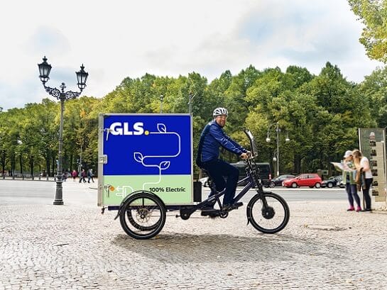 Ein GLS-Mitarbeiter liefert Pakete mit einem GLS-Lastenfahrrad aus