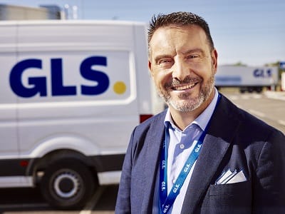 Friendly GLS transport partner standing in front of one of his GLS delivery vans