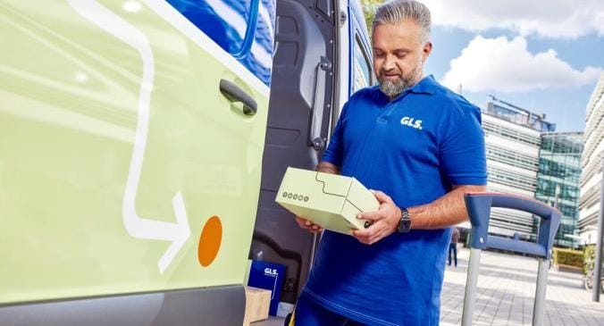 Ein GLS Fahrer hält ein kleines GLS Paket in der Hand