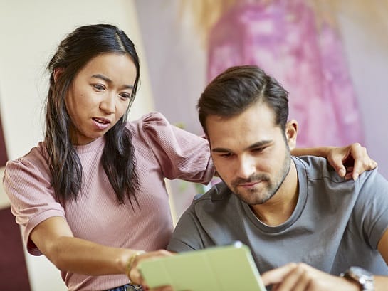 A young woman and a young man give up a shipment on the tablet