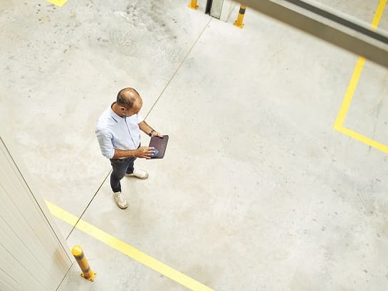 Professional solutions for your business - man standing in the warehouse with a tablet
